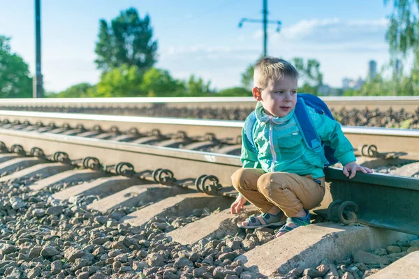 Niño Pequeño Con Una Mochila Está Sentado Los Rieles Descanse — Foto de Stock