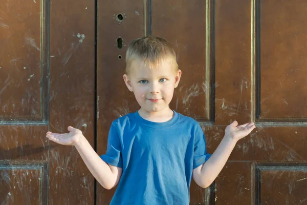 Выражение Невежества Ребенке Мальчик Протягивает Руки Перед Закрытыми Дверьми — стоковое фото