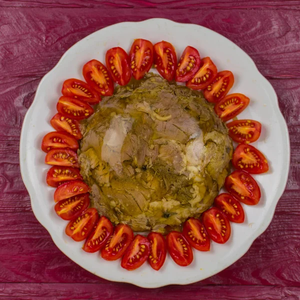 Una Carne Gelatina Piatto Rotondo Decorato Con Pomodori Una Superficie — Foto Stock