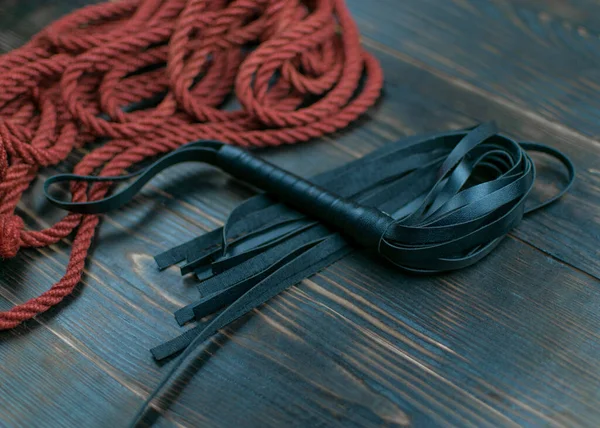 暗い背景に結ぶためにボンデージとロープのための鞭 性的ゲームのためのアクセサリー — ストック写真