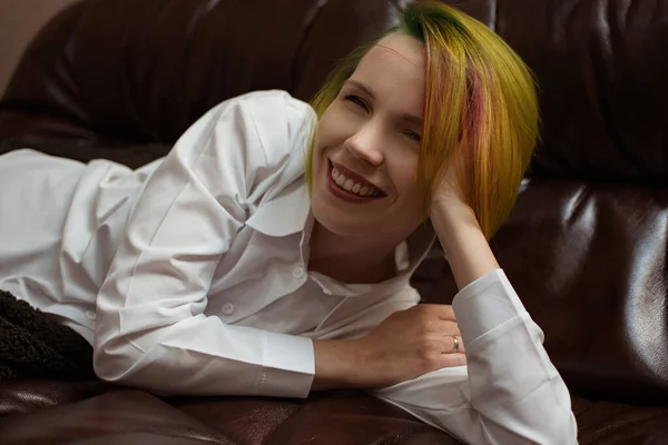 Una Mujer Con Cabello Multicolor Yace Sofá Cuero —  Fotos de Stock