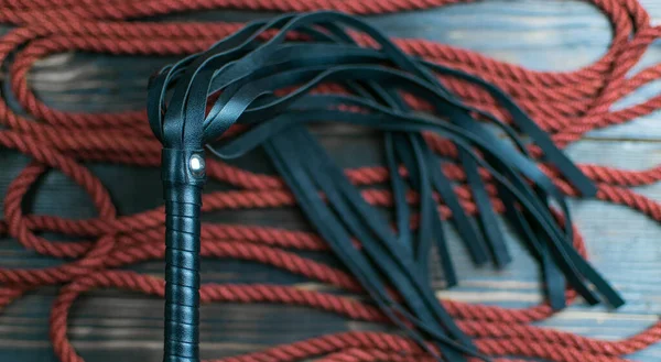 暗い背景に結ぶためにボンデージとロープのための鞭 性的ゲームのためのアクセサリー — ストック写真