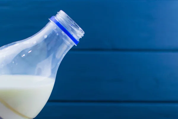 Полузаполненная Открытая Пластиковая Бутылка Молоком Синем Деревянном Фоне — стоковое фото