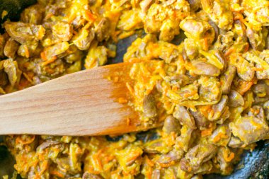 Soğan ve havuçla pişirilmiş tavuk kalbi.