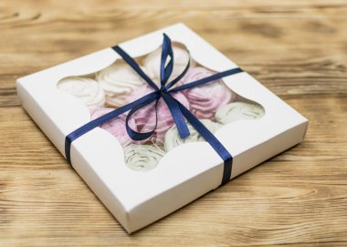 Tahta bir arka planda hediye kutusunda marşmelov. Tatlı hediye..