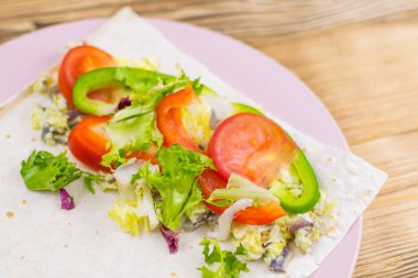 Tahta arka planda bir rulo Pita ekmeği ve taze sebze hazırlamak. Sağlıklı beslenme kavramı.