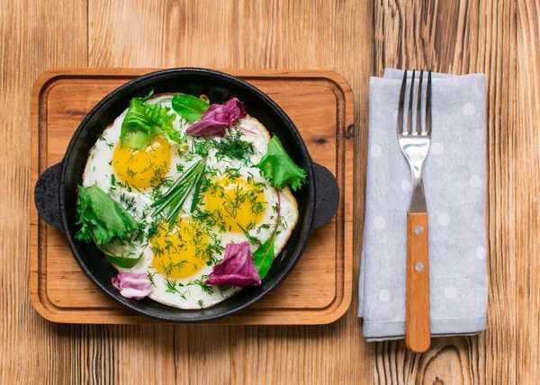 Kızartma tavasında yumurta ve yeşillik.