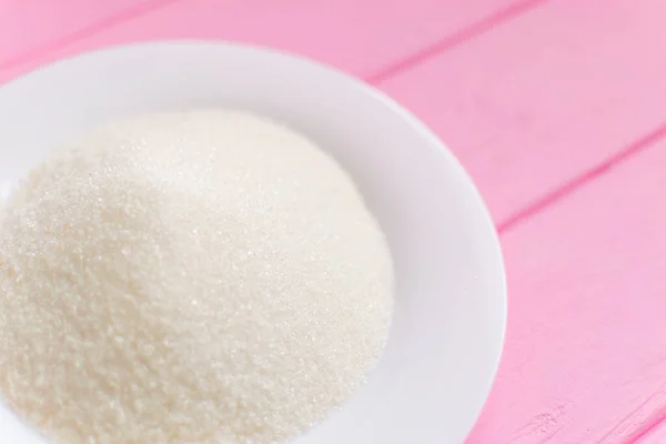 Açúcar Uma Placa Branca Fundo Rosa Madeira — Fotografia de Stock