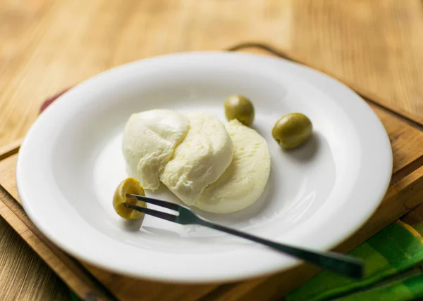 Peynirli Mozzarella Ahşap Arka Planda Bir Tabakta Zeytin — Stok fotoğraf