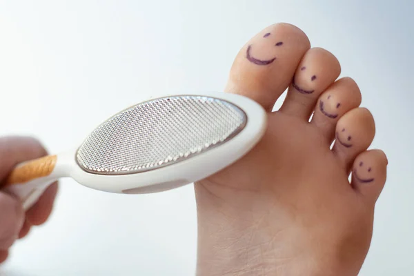 Vrouwelijke Tenen Met Beschilderde Glimlachen Een Pedicure Rasp Voetzorgconcept — Stockfoto