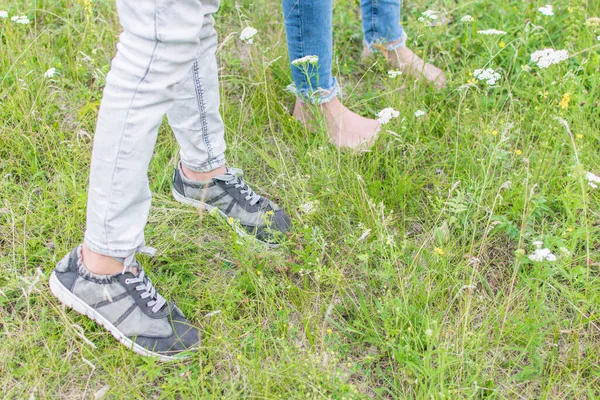 两双腿踩在绿草上 穿着鞋子赤脚在大自然中 — 图库照片