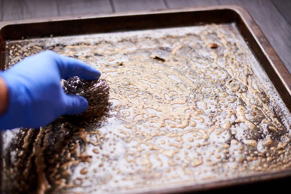 Limpieza Una Bandeja Horno Sucio Con Una Esponja Metal Detergente — Foto de Stock