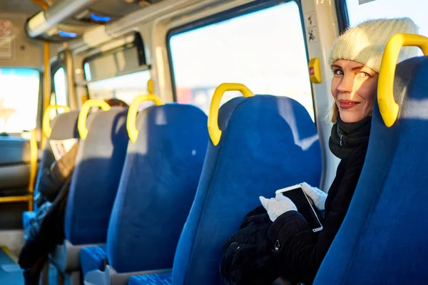 Woman with a phone in a bus.