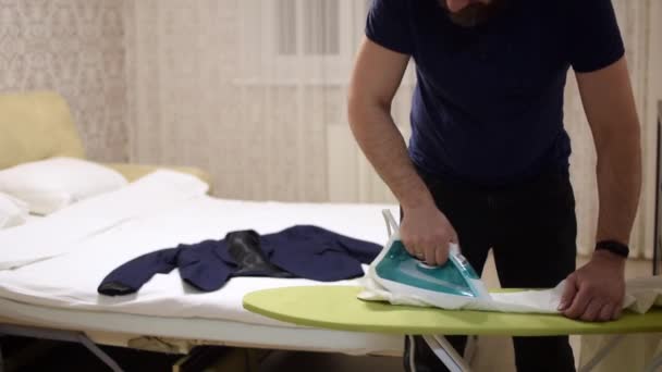 Man Ironing White Shirt Room — Stock Video
