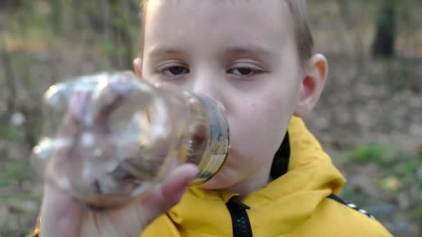 Niño Bebe Una Botella Bosque — Vídeos de Stock