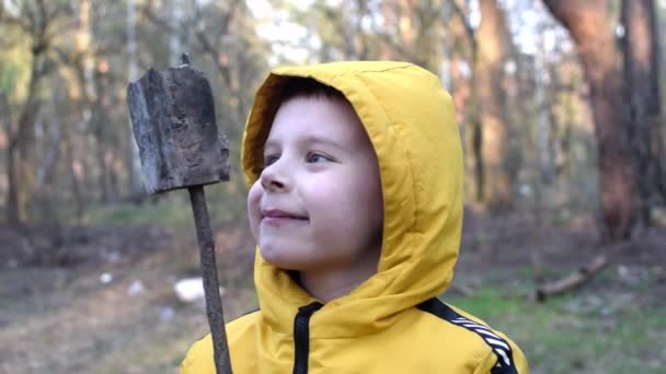 一个微笑的男孩看着森林里的相机 — 图库视频影像