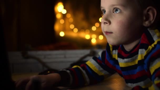 男の子がキーボードを押している 子供はふける暗い部屋のコンピューターで遊ぶ — ストック動画