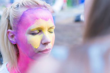 Peri masalı karakterine bürünmüş bir kadının yüzü. Yüze pembe bir su rengi uygulamak.