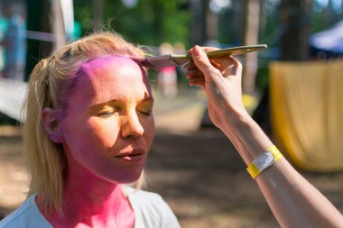 Peri masalı karakterine bürünmüş bir kadının yüzü. Yüze pembe bir su rengi uygulamak.