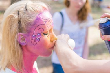 Peri masalı karakterine bürünmüş bir kadının yüzü. Yüze pembe bir su rengi uygulamak.