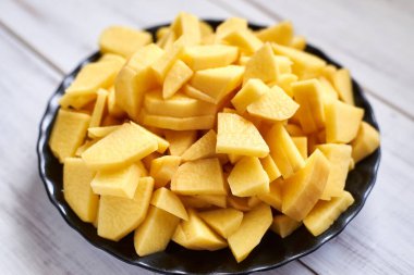 Tahtada dilimlenmiş çiğ patates. Pişirmek için sebze hazırlıyorum..