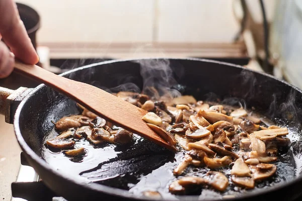 Fried mushrooms in a pan. Cooking mushrooms with steam emanating from them.