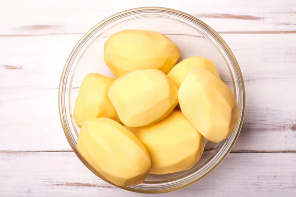 Geschilde Aardappelknollen Een Bord Een Lichte Houten Ondergrond Aardappelen Bereiden — Stockfoto