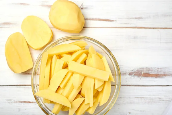 Gesneden Aardappelen Een Bord Een Houten Ondergrond Aardappelen Bereiden Voor — Stockfoto