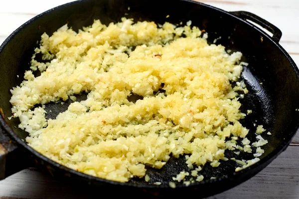 Hafif ahşap arka planda tavada kızarmış soğan. Yemek hazırlığı.