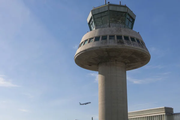 Um avião voa ao lado da torre de controle no Aeroporto de Barcelona, Sp — Fotografia de Stock