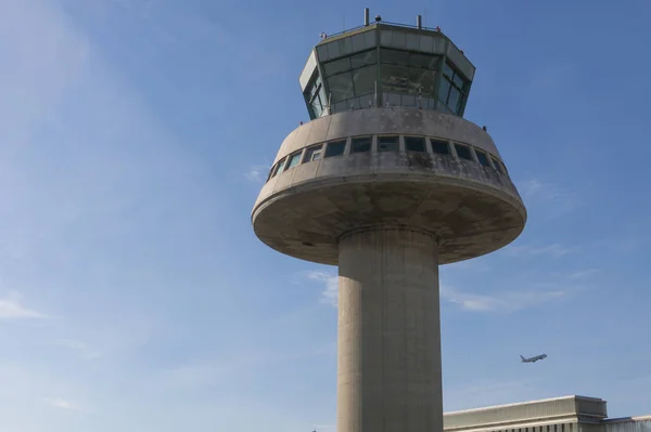 Un avión vuela junto a la torre de control en el aeropuerto de Barcelona, Sp — Foto de Stock