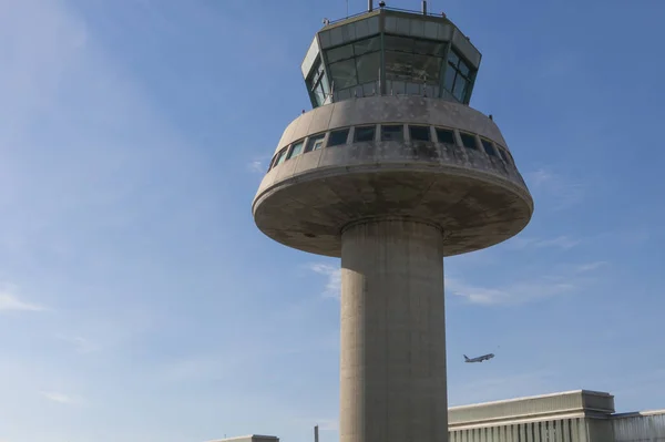 Ein flugzeug fliegt neben dem kontrollturm auf dem flughafen barcelona, sp — Stockfoto