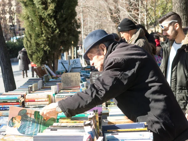 Old men flipping through books Antique Book Store in Moyano's slope near the Buen Retiro Park, Madrid, Spain — Stock Photo, Image