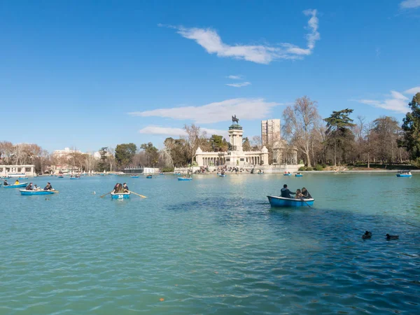 Pessoas desfrutando de um passeio de barco na lagoa no Parque El Retiro, em Madrid, Espanha. El Retiro é o maior parque da cidade de Madrid. Espanha . — Fotografia de Stock