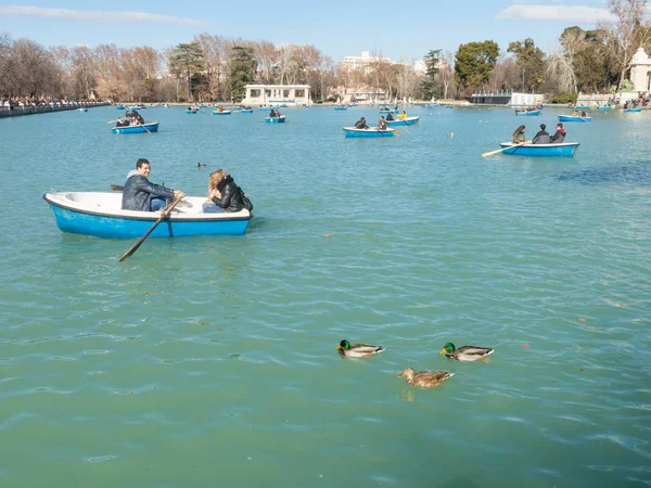 Люди, наслаждающиеся прогулкой на лодке по пруду в парке Эль Ретиро в Мадриде, Испания. Эль-Ретиро является крупнейшим парком города Мадрида. Испания . — стоковое фото