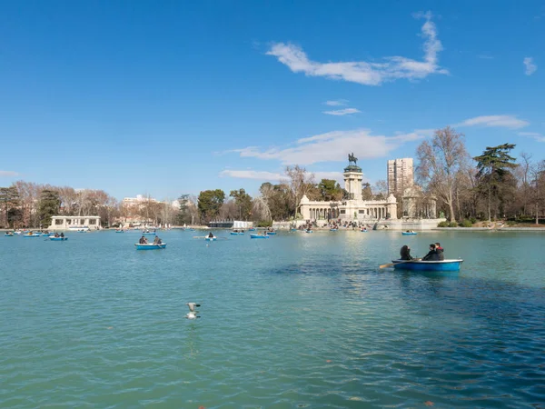 Pessoas desfrutando de um passeio de barco na lagoa no Parque El Retiro, em Madrid, Espanha. El Retiro é o maior parque da cidade de Madrid. Espanha . — Fotografia de Stock