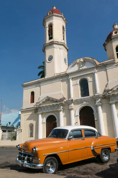 Gamla bilar parkerade i parken Jose Marti, framför Purisima Concepcion katedralen. Staden Cienfuegos, ön Kuba. — Stockfoto