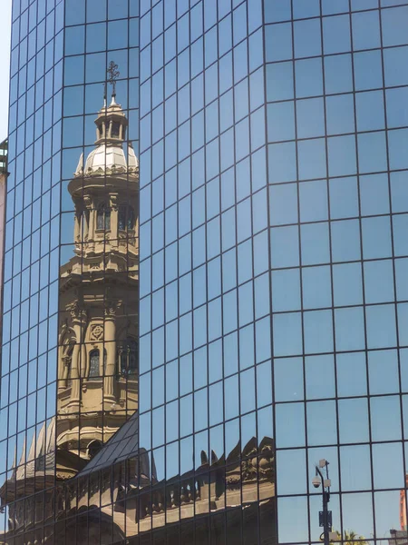 Reflexão em um edifício de vidro da Catedral Metropolitana de Santiago, na praça Armas. É o templo principal da Igreja Católica no país, construído entre 1748-1800. Chile — Fotografia de Stock