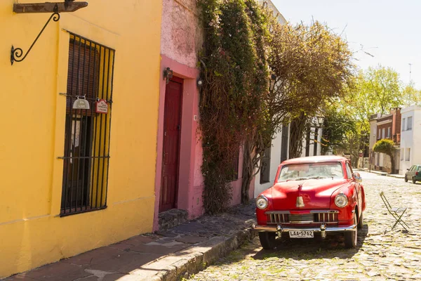 Red automobile on one of the cobblestone streets, in the city of — Stock Photo, Image