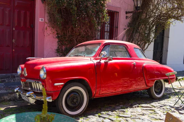 Punainen auto yhdellä mukulakivikaduista, kaupungin keskustassa — kuvapankkivalokuva