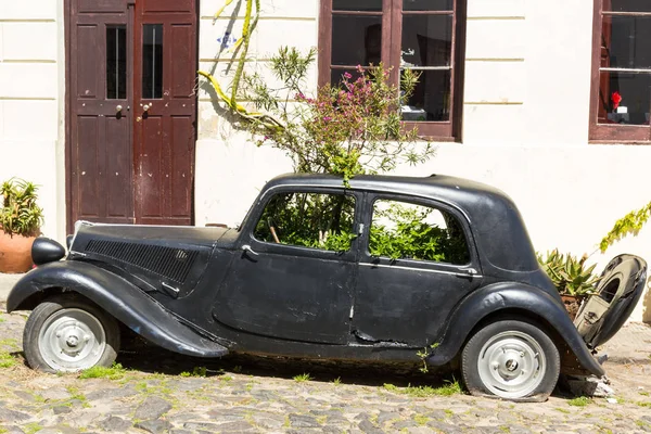 Black and obsolete car on one of the cobblestone streets, in the — Stock Photo, Image