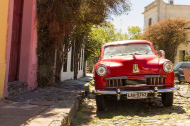 Colonia, Uruguay - 26 Eylül 2012: Uruguay 'ın Colonia del Sacramento şehrindeki kaldırım taşlarından birinde kırmızı otomobil. Uruguay 'ın en eski şehirlerinden biridir..