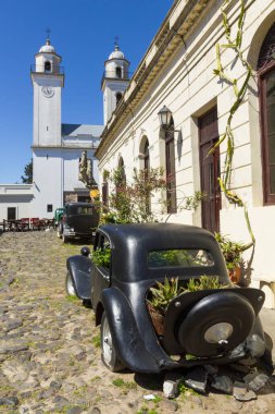 Eski arabalar, Colonia del Sacramento, Uruguay kilisesinin önünde. Uruguay 'ın en eski şehirlerinden biridir. UNESCO 'nun 1995' teki Dünya Mirası.