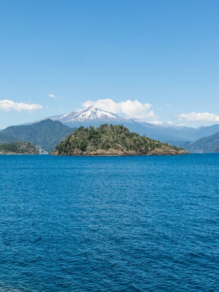 Panguipulli湖の水の上に 雲に囲まれた素晴らしいChoshuenco火山 森の中の木は素晴らしい火山の風景です 素晴らしい雪の頂上キャップ チリの南 ロイヤリティフリーのストック画像