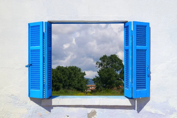 Beautiful countryside throught blue window — Stock Photo, Image
