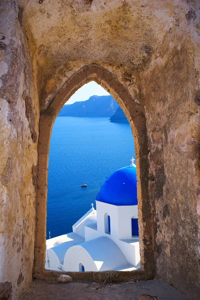 Traditionella grekiska kyrkan genom ett gammalt fönster i Santorini isl — Stockfoto