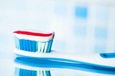 kırmızı çizgili diş macunu ile mavi diş fırçası