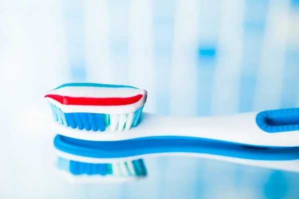赤のストライプの歯磨き粉で青い歯ブラシ — ストック写真