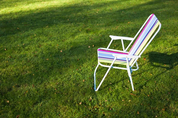 Tuinstoel op groen gras achtergrond — Stockfoto