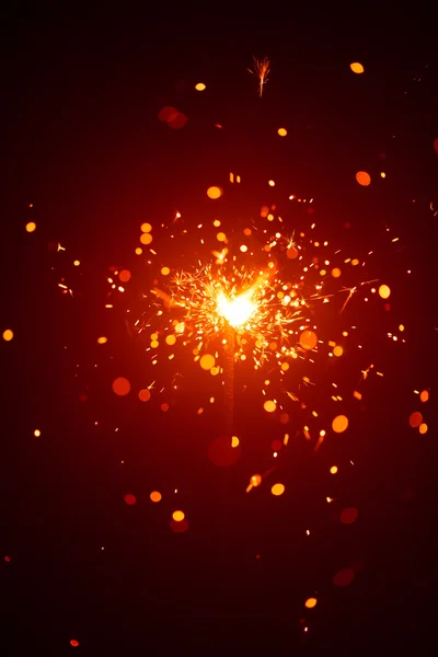 Christmas sparkler in haze with red light — Stock Photo, Image